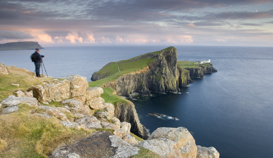 Photographer photographing Neist point lighthouse at dusk
